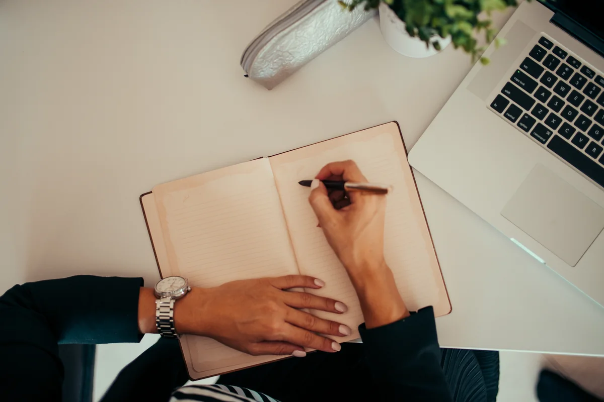 Illustrative note-taking at a laptop; the person is not identified as a patient, clinician or NovCog team member.